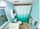 A compact bathroom featuring blue walls, a white vanity, and a tiled shower with a curtain at 1515 Forrest Nelson Blvd # D102, Port Charlotte, FL 33952