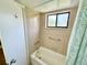 Bathroom featuring tan tile, shower/tub combo and grab bar at 1515 Forrest Nelson Blvd # D102, Port Charlotte, FL 33952