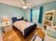 Bedroom showcases blue walls, wooden floors, a floral-patterned bedspread, and a charming decor at 1515 Forrest Nelson Blvd # D102, Port Charlotte, FL 33952
