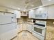 Bright kitchen with white cabinets and appliances plus granite counters at 1515 Forrest Nelson Blvd # D102, Port Charlotte, FL 33952