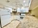 Well-lit kitchen with white appliances, granite countertops, and a view of the sink, offering a functional layout at 1515 Forrest Nelson Blvd # D102, Port Charlotte, FL 33952