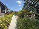 Landscaped walkway with vibrant flowering bushes; a beautifully maintained path through the community at 1515 Forrest Nelson Blvd # D102, Port Charlotte, FL 33952