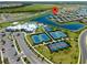 Aerial view showcasing community amenities like tennis and basketball courts, a pool, and scenic lakes and landscaping at 15974 Clear Skies Pl, Bradenton, FL 34211