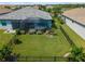 Aerial view of backyard with black fence, green lawn, screened-in lanai with landscaping at 15974 Clear Skies Pl, Bradenton, FL 34211