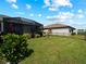 Well-maintained backyard featuring a lush lawn, mature landscaping, and a screened-in lanai for outdoor relaxation at 15974 Clear Skies Pl, Bradenton, FL 34211