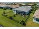 Aerial shot of the backyard featuring a black fence, green lawn, screened-in lanai, and carefully placed landscaping at 15974 Clear Skies Pl, Bradenton, FL 34211