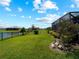 The backyard offers a scenic pond view, lush green grass, and tasteful landscaping at 15974 Clear Skies Pl, Bradenton, FL 34211