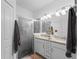 Bathroom with a dual sink vanity, granite countertops, and a glass-enclosed shower at 15974 Clear Skies Pl, Bradenton, FL 34211
