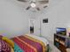 Bedroom with colorful bedding, ceiling fan, and a view into another room at 15974 Clear Skies Pl, Bradenton, FL 34211