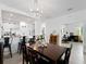 Dining area with a modern chandelier, wood table, and view into the kitchen at 15974 Clear Skies Pl, Bradenton, FL 34211