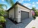 Two car garage with gray doors and paver driveway at 15974 Clear Skies Pl, Bradenton, FL 34211