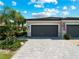 Two car garage with gray doors and paver driveway at 15974 Clear Skies Pl, Bradenton, FL 34211
