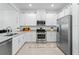Bright kitchen featuring stainless steel appliances, granite counters, white cabinets, and tile flooring at 15974 Clear Skies Pl, Bradenton, FL 34211
