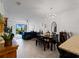 Open concept living room featuring modern chandelier, dining table, and a view to the outside patio at 15974 Clear Skies Pl, Bradenton, FL 34211