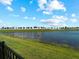 Scenic pond view with a grassy bank and a white fence lined with trees in the background at 15974 Clear Skies Pl, Bradenton, FL 34211
