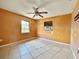 Bedroom features orange walls, tile floors, and natural light at 1611 Robbins Rd, Nokomis, FL 34275