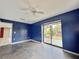 Living room featuring blue accent wall, sliding doors to the outside, and ceiling fan at 1611 Robbins Rd, Nokomis, FL 34275