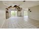 Open living room with tile flooring and fireplace, showing some ceiling damage at 1611 Robbins Rd, Nokomis, FL 34275