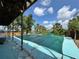 Covered pool with palms and blue skies at 1611 Robbins Rd, Nokomis, FL 34275