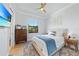 A sunlit bedroom showcases a comfy bed, wooden floors, and a wall-mounted TV at 1801 Los Alamos Dr, Punta Gorda, FL 33950