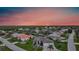 Stunning single Gathering home featuring well manicured lawn, three-car garage and a paved driveway at sunset at 1801 Los Alamos Dr, Punta Gorda, FL 33950