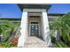 Elegant front entrance with a modern door, stone steps, and lush tropical landscaping at 1801 Los Alamos Dr, Punta Gorda, FL 33950
