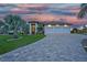 Beautiful home at dusk featuring a three car garage, landscaped yard, and paver driveway at 1801 Los Alamos Dr, Punta Gorda, FL 33950