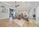 Bright living room with sectional sofa, wood floors, ceiling fan, and open flow to kitchen and patio at 1801 Los Alamos Dr, Punta Gorda, FL 33950