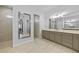 Bright bathroom with double vanities, neutral tiling, and glass enclosed walk-in shower at 1801 Los Alamos Dr, Punta Gorda, FL 33950