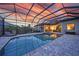 Covered outdoor pool area with brick patio, lounge chair, and sunset sky view, perfect for relaxation at 1801 Los Alamos Dr, Punta Gorda, FL 33950