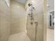 Walk-in shower with floor-to-ceiling tiling, handheld shower, and multiple shelves at 1801 Los Alamos Dr, Punta Gorda, FL 33950