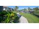Scenic waterfront view with a stone pathway, lush greenery, and a boat dock, offering a serene setting at 1801 Los Alamos Dr, Punta Gorda, FL 33950