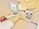 A kitchen featuring white countertops, cabinets, and appliances, illuminated by a window at 18335 Oxford Ave, Port Charlotte, FL 33948
