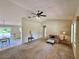 Inviting living room with neutral tones and a ceiling fan, seamlessly connected to the dining area at 18335 Oxford Ave, Port Charlotte, FL 33948