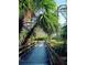 A wooden bridge framed by lush tropical vegetation, inviting exploration and relaxation at 18335 Oxford Ave, Port Charlotte, FL 33948