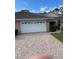 Inviting single-story home featuring a brick driveway and a spacious two-car garage at 2023 Lynx Run, North Port, FL 34288