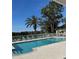 Community pool area with lounge chairs, palm trees, and a clear blue sky at 2023 Lynx Run, North Port, FL 34288