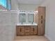 Bathroom featuring double sinks, framed mirrors, and natural wood cabinetry at 2089 Garnet St, North Port, FL 34288