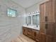Bathroom featuring double sinks, framed mirrors, and a walk-in shower with marble tile at 2089 Garnet St, North Port, FL 34288
