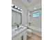 A vanity and toilet in a bathroom with marble tile in the shower at 2089 Garnet St, North Port, FL 34288