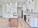 Bright kitchen features white cabinets, sleek black hardware, pendant lighting, and a center island at 2089 Garnet St, North Port, FL 34288