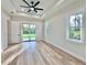 Main bedroom featuring a tray ceiling, fan, and sliding door access to the backyard at 2089 Garnet St, North Port, FL 34288
