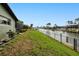 View of backyard canal frontage with lush grass and black chain link fence at 2160 Aqui Esta Dr, Punta Gorda, FL 33950