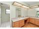 Bathroom featuring a double sink vanity with wooden cabinets, and two doors at 2160 Aqui Esta Dr, Punta Gorda, FL 33950