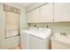 Functional laundry room with cabinetry and washer/dryer units under a window at 2160 Aqui Esta Dr, Punta Gorda, FL 33950