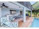 Covered pool patio with wet bar, ceiling fans, and comfortable lounge seating for outdoor entertaining at 2160 Aqui Esta Dr, Punta Gorda, FL 33950