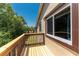 Outdoor balcony with wood flooring, a brown railing, and views of the trees at 22481 Westchester Blvd # B48, Punta Gorda, FL 33980