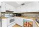 Bright kitchen features white appliances, white cabinets, wood countertops, and unique cardinal-themed dishwasher panel at 22481 Westchester Blvd # B48, Punta Gorda, FL 33980