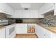 Bright kitchen with white appliances, white cabinets, wood countertops, and unique cardinal-themed dishwasher panel at 22481 Westchester Blvd # B48, Punta Gorda, FL 33980