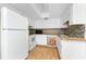 Bright kitchen has white appliances, white cabinets, wood countertops and unique cardinal-themed dishwasher panel at 22481 Westchester Blvd # B48, Punta Gorda, FL 33980